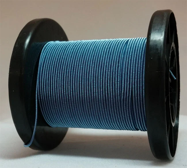 Blue home-made enamelled and spun copper wire on a reel